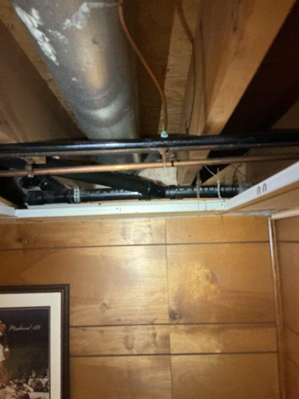 Responded to complaint of gurgling noises and odors emanating from garage sink drain when kitchen sink was in use. Conducted inspection of drainage system and plumbing connections in garage area. Upon examination, identified improper venting or potential partial blockage in shared drain line causing air pressure issues between fixtures. Documented existing plumbing configuration including exposed drain lines and mechanical systems for service records. Explained to customer that gurgling sounds indicate negative air pressure in the drain system, typically caused by inadequate venting or restriction in the common waste line. Recommended follow-up evaluation of vent stack and potential drain line cleaning to resolve cross-fixture drainage issues and eliminate odor problems.
