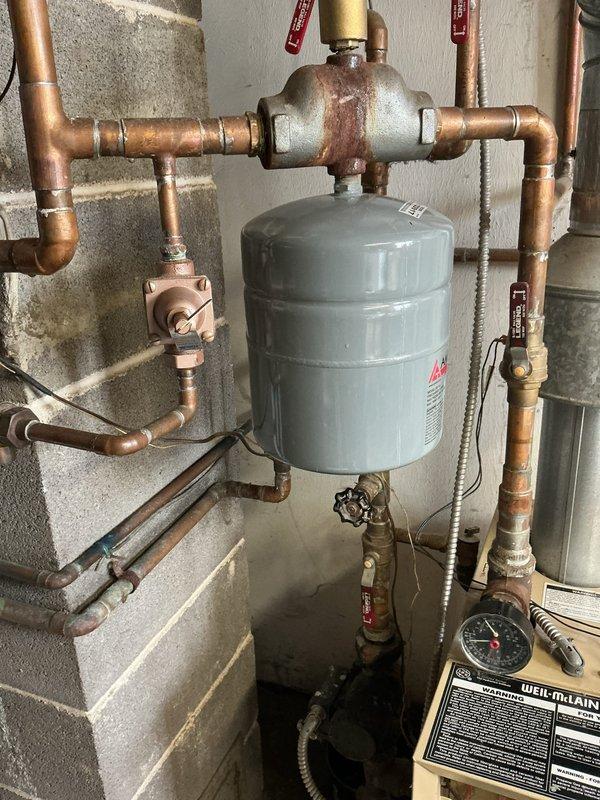 Responded to water leak issue affecting multiple baseboard heating units supplied by aging 16+ year old boiler system. Upon inspection, found active leaks at several baseboard connections requiring immediate shutdown of boiler to prevent further water damage. Documented existing hydronic heating system configuration including expansion tank, circulator pump, zone valves, and copper piping network showing significant age-related corrosion and oxidation throughout. System remains offline pending customer decision on repair versus replacement options given the advanced age of equipment and extent of deterioration observed in piping components.
