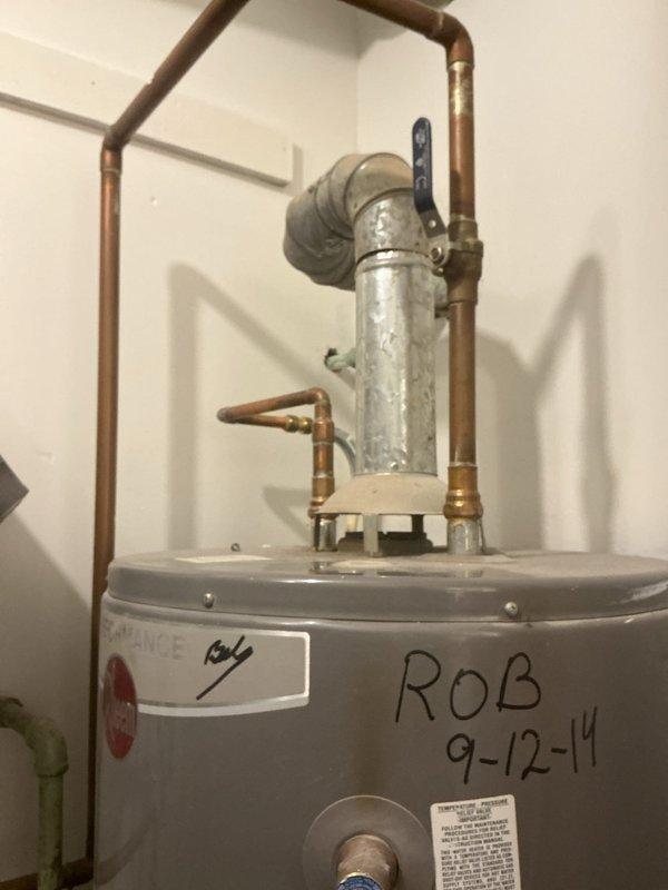 Responded to service call for leaking 40-gallon residential tank water heater. Upon inspection, confirmed active leak originating from bottom of tank, indicating internal tank failure. Unit manufactured in September 2014, showing approximately 10 years of service life. Documented existing installation configuration including copper supply lines with brass fittings, galvanized steel temperature and pressure relief valve discharge pipe, and current piping layout. Photographed unit specifications, safety labels, and installation details. Provided comprehensive quote for complete water heater replacement due to non-repairable tank breach.