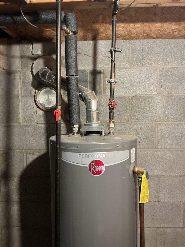 Responded to service call for toilet fill valve spraying water inside tank. Upon inspection, identified defective fill valve assembly causing water to spray internally rather than fill properly through designated outlet. Assessed that the issue likely stems from failed internal washer or rubber seal within the valve mechanism, though complete disassembly was not performed during initial diagnostic visit. Documented plumbing system configuration and water heater connections in utility area for reference. Recommended fill valve replacement to resolve the continuous spray condition and restore proper tank filling operation.