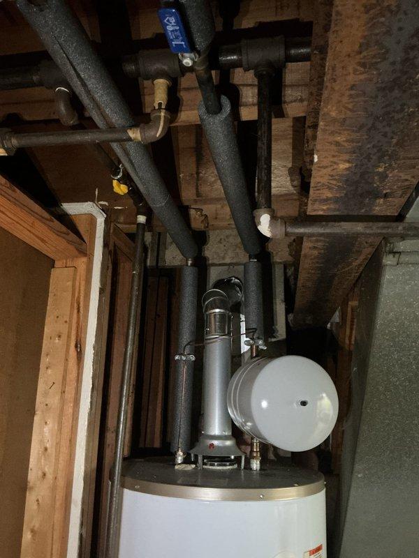 Responded to service call regarding reported issue with tanked water heater system. Upon arrival, performed comprehensive inspection of Whirlpool tank-style water heater unit installed in basement utility area. Evaluated all plumbing connections, including inlet and outlet piping, pressure relief valve, expansion tank mounting, and associated black insulated supply lines. Assessed water heater operation, temperature settings, and proper venting. Verified expansion tank was properly charged and functioning correctly. Inspected all visible copper and PEX connections for leaks or corrosion. Confirmed unit specifications and safety labels were intact and legible. Documented existing installation configuration with photos showing water heater positioning, expansion tank placement, valve locations, and overall plumbing infrastructure layout. System found to be operating within normal parameters upon completion of diagnostic evaluation.