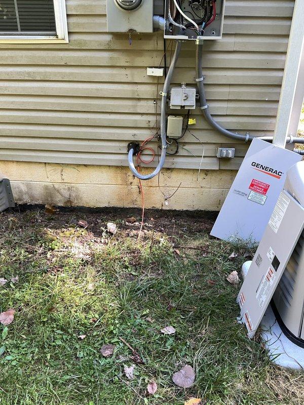 Responded to service call for 5-month-old Generac generator system with no power. Upon arrival, discovered exposed and severed ground wire between generator and main electrical panel. Inspected exterior electrical installation including transfer switch, meter base, and conduit runs mounted on residential siding. Located damaged grounding conductor at base of installation near concrete foundation. Replaced compromised ground wire with properly sized copper grounding conductor, securing it through existing conduit pathway from generator transfer switch to main service panel. Verified all electrical connections at transfer switch, meter base, and panel box for proper torque and integrity. Tested generator startup sequence and confirmed successful power transfer to home electrical system. Ensured all grounding connections met NEC requirements and verified continuity of grounding system throughout installation. System restored to full operational status with proper grounding protection in p