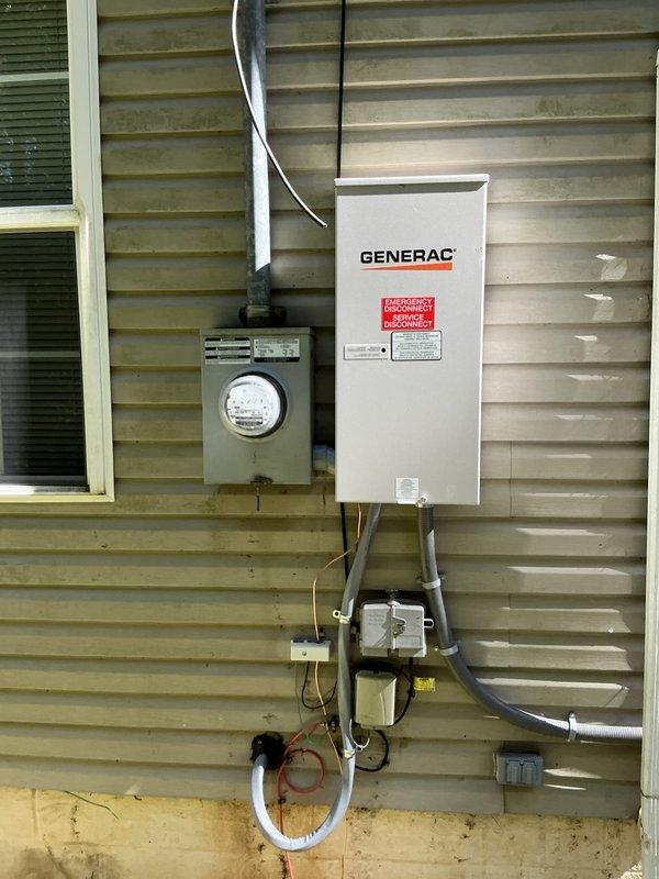 Responded to service call for 5-month-old Generac generator system with no power. Upon arrival, discovered exposed and severed ground wire between generator and main electrical panel. Inspected exterior electrical installation including transfer switch, meter base, and conduit runs mounted on residential siding. Located damaged grounding conductor at base of installation near concrete foundation. Replaced compromised ground wire with properly sized copper grounding conductor, securing it through existing conduit pathway from generator transfer switch to main service panel. Verified all electrical connections at transfer switch, meter base, and panel box for proper torque and integrity. Tested generator startup sequence and confirmed successful power transfer to home electrical system. Ensured all grounding connections met NEC requirements and verified continuity of grounding system throughout installation. System restored to full operational status with proper grounding protection in p