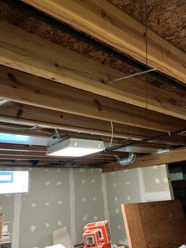Conducted comprehensive electrical estimate for standby generator installation in unfinished basement area. Assessed existing electrical infrastructure, documented exposed ceiling joists with current ductwork and wiring, evaluated wall conditions and available space for transfer switch and generator connection requirements. Photographed site conditions including structural elements, drywall installation progress, and basement layout to develop accurate scope of work for permanent generator system installation.