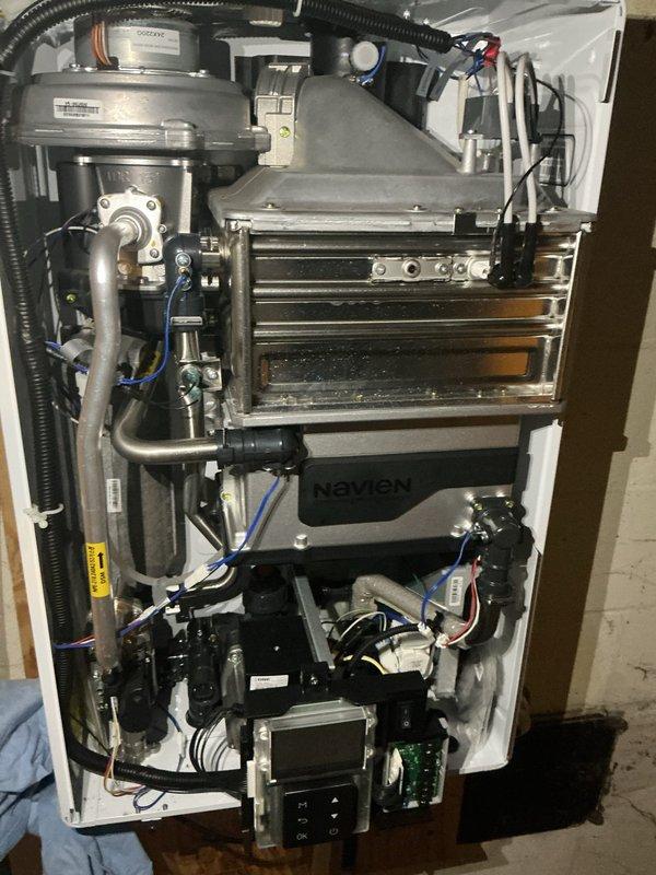 Performed descaling maintenance service on Navien tankless water heater unit. Accessed internal components by removing front panel, flushed heat exchanger assembly with descaling solution to remove mineral buildup and restore optimal heat transfer efficiency. Verified proper operation of pump assembly, electrical connections, and control board functionality upon completion.