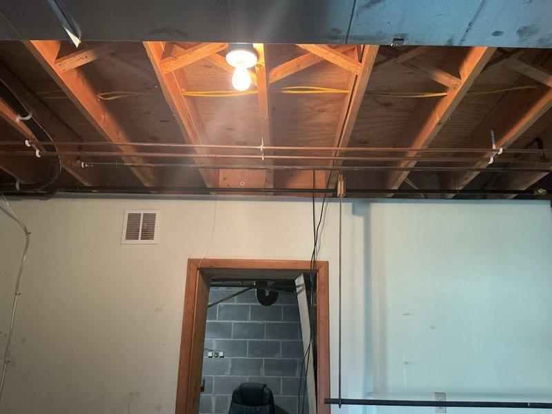Installed gas line routing for attic-mounted gas furnace installation. Ran black iron pipe from exterior meter location through basement ceiling joists to attic furnace position, ensuring proper support brackets and code-compliant installation throughout run.
