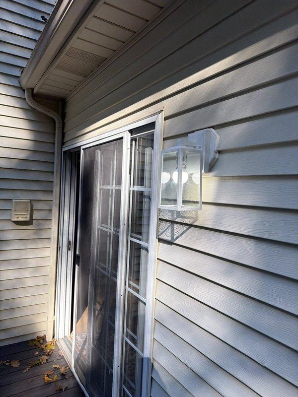 Replaced exterior sconce light fixtures on basement and upstairs patio areas with new customer-selected units. Ran dedicated power supply from existing outlet behind Ring camera to provide constant power to camera portion while maintaining phone-controlled operation of integrated light feature. Addressed callback issue by pulling constant power from basement junction box near television and connecting to red traveler leg of far left switch, capping off unused conductor. Installed wireless 3-way switching system with hardwired receiver at one location and remote transmitter at opposite end, utilizing red traveler as constant hot and existing switch leg. Configuration allows exterior lighting operation independent of outdoor receptacle circuits, ensuring continuous power availability to exterior outlets while maintaining full lighting control functionality.