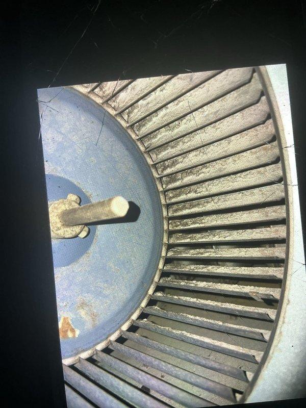 Responded to service call for 9-year-old natural gas furnace following fire department visit due to elevated CO2 levels. Performed comprehensive safety inspection of furnace and surrounding area. Upon examination, discovered heavily soiled blower wheel assembly with significant dust and debris accumulation, which can restrict airflow and impact combustion efficiency. Inspected burner assembly, heat exchanger, and venting system for potential carbon monoxide sources. Documented condition of Aprilaire 500 Series humidifier and overall HVAC system components. Blower assembly showed signs of aging with visible rust on access panel and mounting hardware. Recommended immediate cleaning of blower wheel to restore proper airflow, professional combustion analysis to verify safe CO levels, and potential heat exchanger inspection to rule out cracks or failures that could cause carbon monoxide concerns.