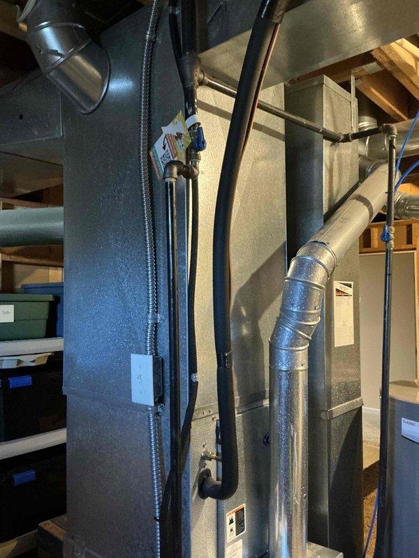 Conducted comprehensive replacement estimate for 22-year-old residential air conditioning system. Evaluated existing HVAC infrastructure in basement utility area, including vertical air handler unit, associated ductwork, and RUUD brand equipment. Documented current system configuration with detailed photographs showing air handler placement, metallic exhaust venting, water heater proximity, and existing duct runs to provide accurate replacement specifications and equipment recommendations.