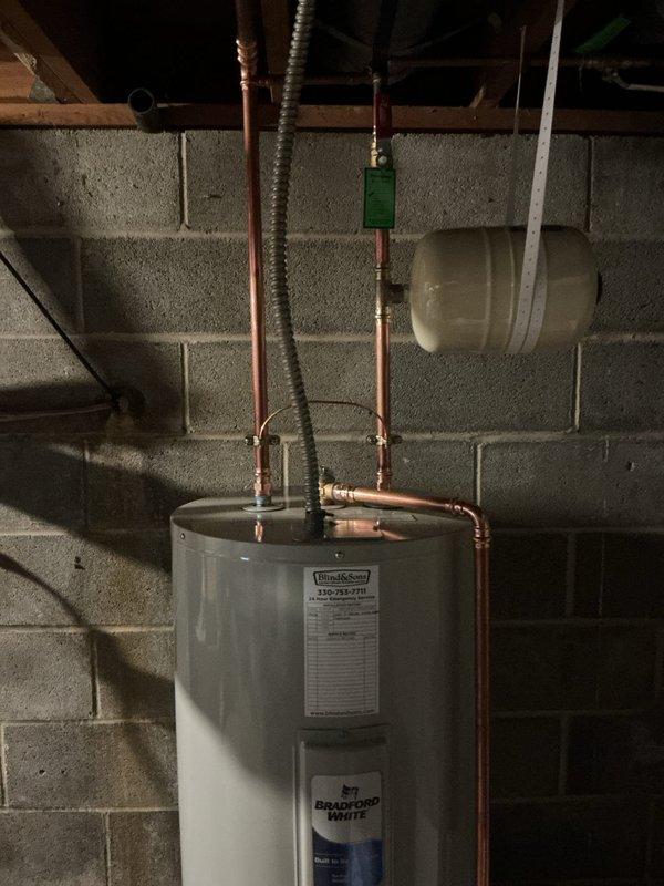 Replaced existing AO Smith 50-gallon electric water heater with new Bradford White 50-gallon electric unit including 6-year manufacturer warranty. Installation included new ball valve, proper bonding wire, and thermal expansion tank. Repaired leaking hot water side piping and replaced corroded shut-off valve on hot water line. Removed and capped corroded shut-off valve located in ceiling near laundry tub. Replaced corroded straight stops under kitchen sink and eliminated unused saddle valve previously connected to ice maker.