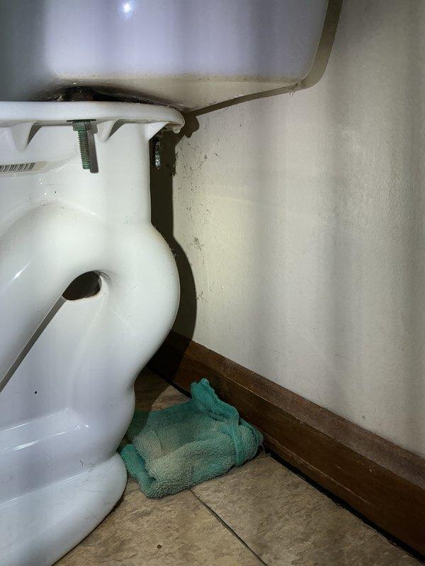 Responded to bathroom water leak complaint and performed thorough inspection of plumbing fixtures. Identified moisture accumulation at toilet base in corner area and inspected vanity plumbing connections for potential leak sources. Examined supply line connections, drain assemblies, and fixture mounting points to determine origin of water intrusion. Addressed leak issue and verified proper operation of all bathroom plumbing fixtures upon completion.