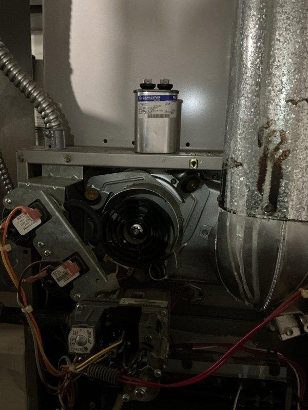 Responded to service call for 31-year-old gas furnace running but blowing cold air. Upon inspection, documented heavily soiled evaporator coil with significant dust and debris accumulation restricting airflow, and examined blower motor assembly with capacitor and electrical components showing age-related wear and deterioration on ductwork. Preventive maintenance visit scheduled for follow-up to address system performance issues.