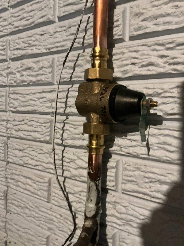 Responded to a follow-up service call to inspect a possible leak from a recently installed expansion relief tube and evaluate a suspected failing pressure reducing valve from a prior installation. Upon inspection, assessed the plumbing valve assembly and pressure regulation system mounted on the utility room wall, including the copper piping connections, pressure gauge readings, and water meter functionality. Customer confirmed the service visit and findings were documented with photographic evidence of the installation condition.