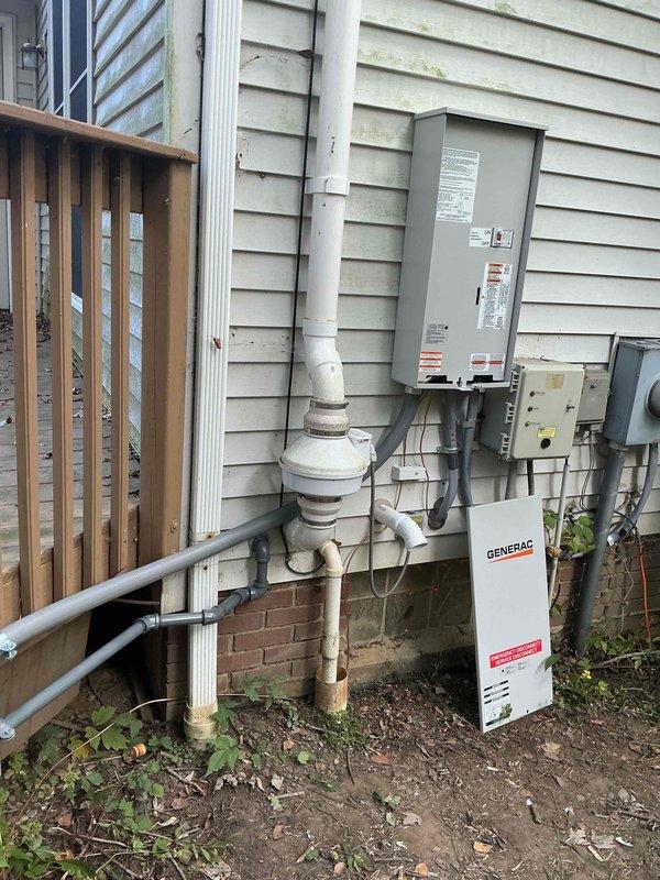 Completed installation of 24kW Generac home standby generator with 200-amp automatic transfer switch and whole home surge protector. Installed oil warmer for cold weather operation. Ran approximately 20 feet of electrical conduit from main service panel to generator location and coordinated with gas line contractor for 30 feet of natural gas supply line installation. Mounted generator on exterior concrete pad adjacent to house, installed gray electrical panel and white Generac transfer switch on vinyl siding with proper clearances. Routed white PVC and gray conduit along exterior wall using appropriate fittings and supports. Configured system for whole-home backup power operation without requiring utility disconnect. All electrical connections completed per NEC standards and manufacturer specifications. System tested and operational upon completion.