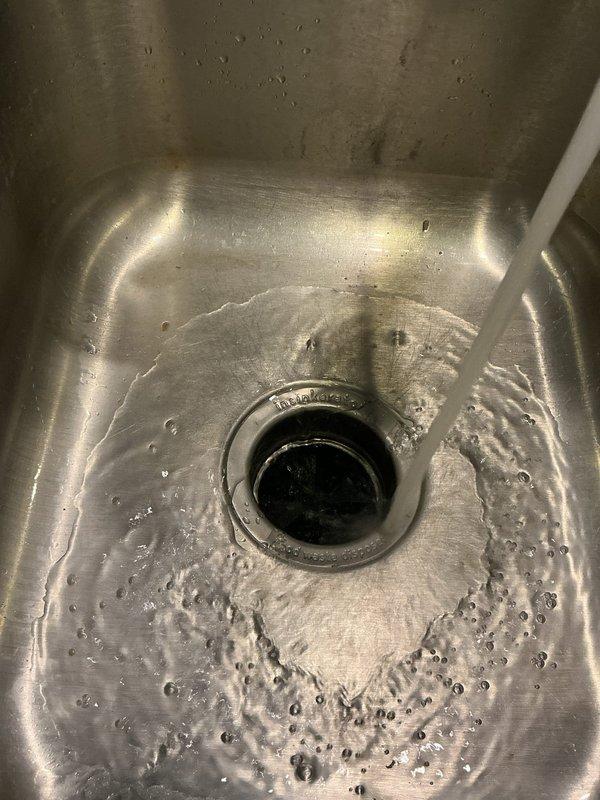 Responded to service call for garbage disposal evaluation and replacement. Upon inspection, assessed existing InSinkErator disposal unit mounted beneath kitchen sink. Evaluated disposal condition, mounting assembly, and associated plumbing connections including PVC drainage piping and electrical wiring. Completed disposal replacement, ensuring proper mounting flange installation, secure drainage connections, and electrical hookup. Verified unit operation and tested for proper drainage flow. Left work area clean with disposal functioning properly.