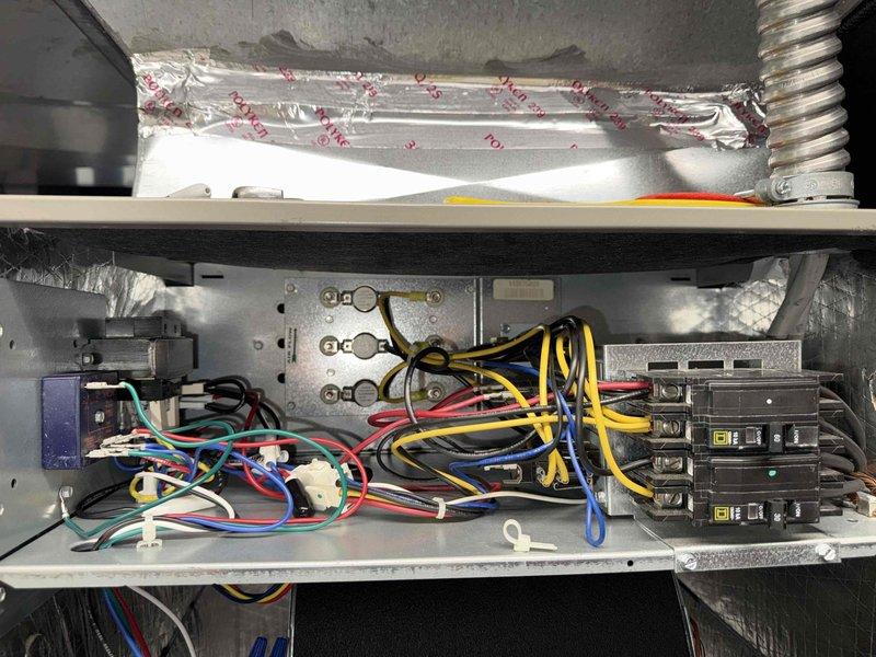 Completed comprehensive MVP heating maintenance on residential air handler unit. Performed thorough inspection of evaporator coil assembly, verified A-frame coil configuration showing clean aluminum fins and copper tubing in proper condition. Examined refrigerant lines including copper coiled loop with insulation, confirmed all connections secure with no visible leaks or damage. Inspected condensate drain pan and drainage system, verified proper flow and positioning. Evaluated electrical control panel and circuit breaker configuration, checked all wire connections including high and low voltage circuits with yellow, red, blue, and black conductors properly terminated. Confirmed all wire nuts and connectors secure, verified electrical junction box and control module functioning correctly. Inspected interior cabinet insulation and structural components, all found in acceptable working condition. Unit operational and ready for heating season.
