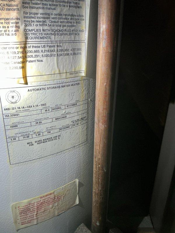 Responded to emergency service call for leaking water heater. Upon arrival, performed comprehensive inspection of automatic storage water heater unit located in basement utility area. Identified active leak requiring immediate attention to prevent further water damage and system failure. Documented existing installation including copper supply lines, expansion tank, shutoff valves, and venting configuration. Assessed unit condition, noting age-related deterioration of plumbing components and oxidation on copper piping. Captured detailed photographs of water heater specifications, manufacturer labels, and overall mechanical room setup for service records and customer documentation.