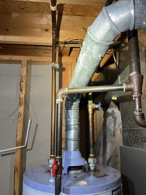 Responded to emergency service call for leaking water heater. Upon arrival, performed comprehensive inspection of automatic storage water heater unit located in basement utility area. Identified active leak requiring immediate attention to prevent further water damage and system failure. Documented existing installation including copper supply lines, expansion tank, shutoff valves, and venting configuration. Assessed unit condition, noting age-related deterioration of plumbing components and oxidation on copper piping. Captured detailed photographs of water heater specifications, manufacturer labels, and overall mechanical room setup for service records and customer documentation.
