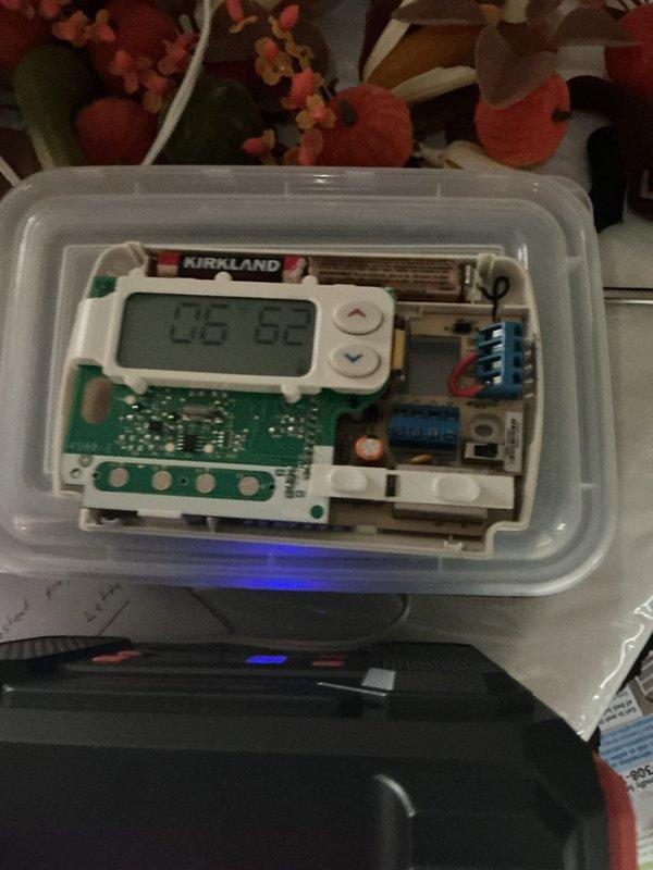 Responded to service call for erratic thermostat displaying incorrect temperature readings (fluctuating between 14°F and 82°F while actual room temperature was 60-80°F). Upon inspection, diagnosed 10-year-old Emerson thermostat with faulty temperature sensor and failing display circuit board. Removed malfunctioning thermostat from wall, documented internal components showing deteriorated circuit board connections and compromised sensor calibration. Replaced defective thermostat with new unit, verified proper wiring connections, and tested system operation to confirm accurate temperature readings and proper HVAC system communication.