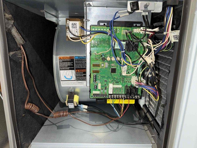 Completed comprehensive furnace tune-up including inspection of control board components, DIP switch configuration verification, and examination of all electrical connections and wiring harnesses. All system components including inductors, capacitors, and control circuitry were found to be in proper working condition with secure connections throughout the unit.