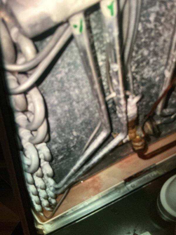Performed a heating maintenance inspection of the furnace/air handler, including a visual check of the ECM drive control board, low-voltage wiring, and cabinet for signs of rust, damage, or loose connections, with none observed. Identified heavy frost and ice accumulation on the evaporator coil and copper refrigerant lines, indicating a restricted airflow or low refrigerant charge condition, and documented the corroded drain pan for further evaluation and corrective repair.