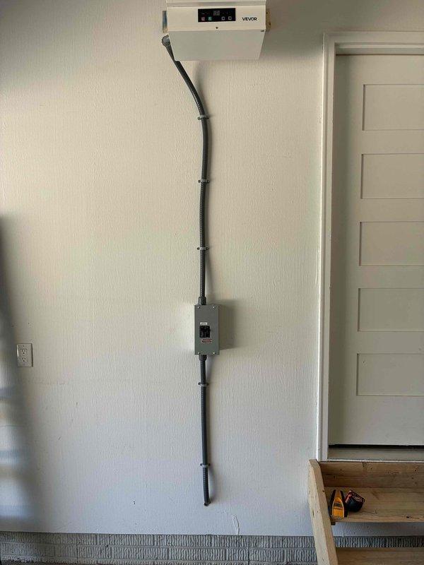 Installed a dedicated circuit from the main electrical panel to the garage to serve a new wall-mounted electric unit heater, fishing the wiring through the structure to minimize wall damage. Mounted a disconnect switch at the heater location and connected the unit with a flexible metal conduit whip, leaving the installation secure, properly supported, and ready for operation.