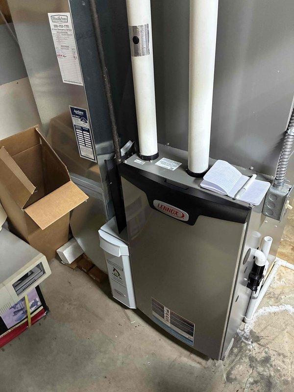 Performed a comprehensive heating maintenance inspection on a Lennox gas furnace with Aprilaire air handler, verifying condensate drain piping and neutralizer operation and checking flue venting and electrical connections. Inspected the evaporator coil assembly and found frost/mineral buildup on the coil and tubing along with heavy rust-colored staining in the drain pan, and recommended cleaning and further evaluation to ensure proper airflow and drainage.