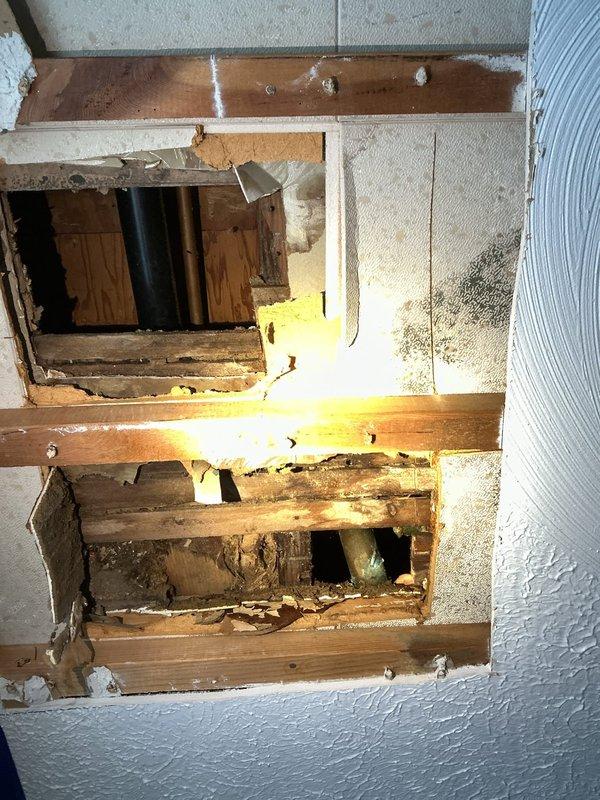 Cleared a clogged bathtub drain and addressed the broken overflow pipe, which had separated from the tub assembly. Access openings were made in the ceiling below to reach the drain and overflow piping, where heavy corrosion, mineral buildup, and deteriorated framing were found around the connections. The drain and overflow assembly was serviced to restore proper drainage, and the corroded condition of the drain ring and pipe stub was documented for the customer's awareness.
