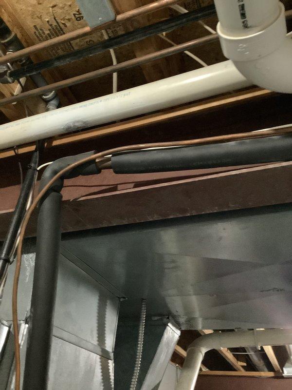 Performed an on-site evaluation for replacement of the existing 29–30 year old HVAC system, inspecting the indoor air handling equipment, galvanized supply ductwork, insulated copper refrigerant lines, condensate drain piping, and the outdoor condensing unit with its electrical disconnect. Noted heavy rust staining and corrosion at the refrigerant line wall penetration, along with uneven and deteriorated line set insulation, which should be addressed during replacement. No active system failures were identified at the time of inspection, and the equipment is being evaluated for proactive replacement due to age.