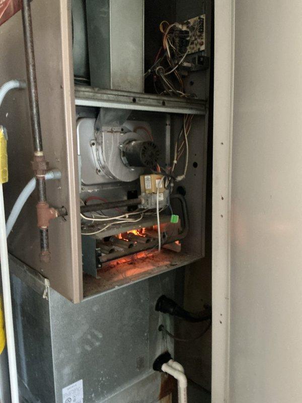Responded to a service call to evaluate the gas control valve on a gas-fired furnace (Ultra 80). Removed the front access panel and inspected the valve, wiring, gas supply piping, blower assembly, and burner compartment, observing normal burner flame with heavy dust and debris buildup on interior surfaces. Documented the unit's condition with photos and prepared an estimate for gas valve replacement.
