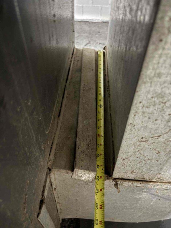 Performed an on-site furnace replacement estimate, measuring the available clearance and installation space around the existing unit for proper equipment sizing and fitment. Inspected the supply plenum and duct connections, noting surface rust on the galvanized elbow, a compressed flexible duct connection at the collar, and heavy dust and debris accumulation throughout the system. Documented all findings with photos to support replacement recommendations and any necessary duct modifications.