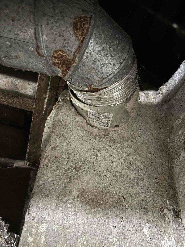 Performed an on-site furnace replacement estimate, measuring the available clearance and installation space around the existing unit for proper equipment sizing and fitment. Inspected the supply plenum and duct connections, noting surface rust on the galvanized elbow, a compressed flexible duct connection at the collar, and heavy dust and debris accumulation throughout the system. Documented all findings with photos to support replacement recommendations and any necessary duct modifications.