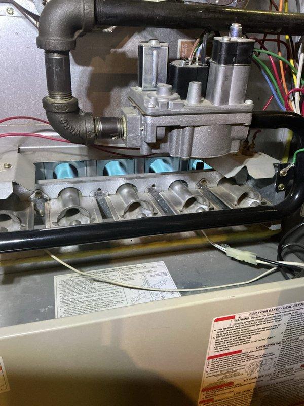 Performed a tune-up on a 28-year-old gas furnace, inspecting the burner assembly, gas valve, manifold, and gas piping, with burners exhibiting a normal blue flame pattern. Verified the low-fire and high-fire pressure switches and associated wiring connections were intact and in serviceable condition, with only light dust and wear observed and no signs of rust, frost, or component damage. Confirmed safety labels and operating instructions were present and the unit was functioning properly at completion.