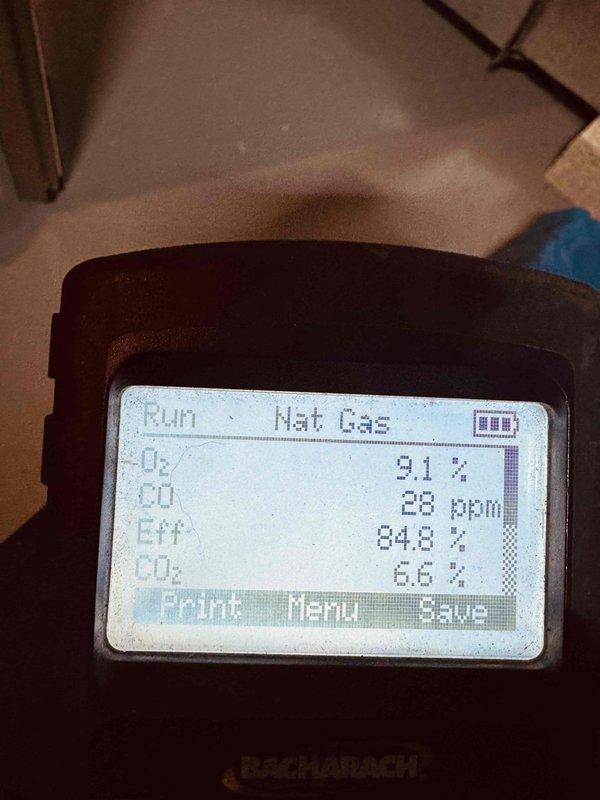 Performed annual tune-up on 4-year-old gas furnace, including combustion analysis with a Bacharach analyzer (O2 9.1%, CO 28 ppm, CO2 6.6%, efficiency 84.8%) to verify safe, proper operation. Inspected the blower assembly and squirrel-cage wheel, finding only light dust on the housing and blade edges with no damage or significant buildup; the system was left operating normally.