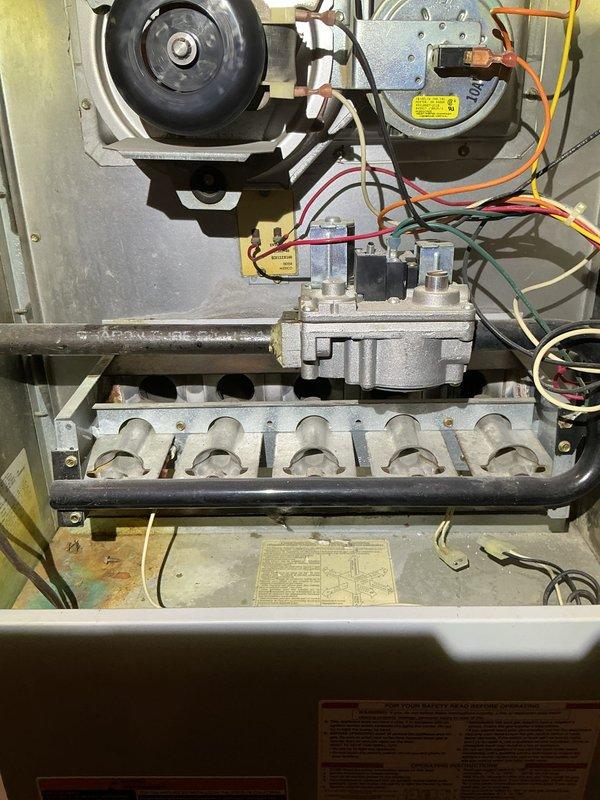 Performed annual maintenance on a 26-year-old gas furnace, inspecting the burner assembly, heat exchanger inlets, gas valve and manifold, inducer motor, flame sensor, and control wiring. Noted surface corrosion and staining in the burner compartment and cleaned debris from the cabinet and burner area. Per the customer's note, the two front-door buttons were tested, with one operating and one not; the nonfunctioning button is recommended for further diagnosis and repair.