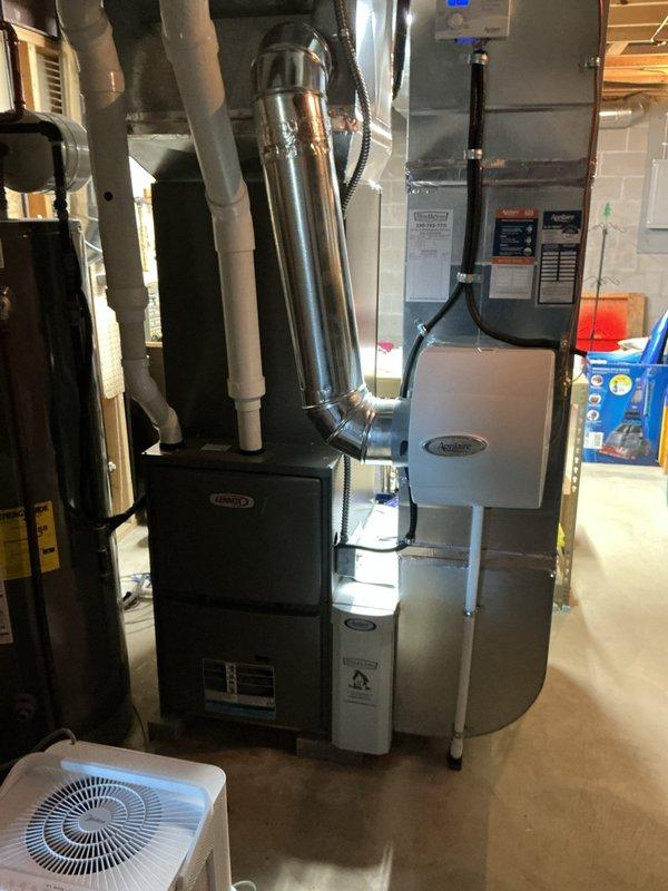 Performed a full seasonal tune-up on the Lennox gas furnace, including removal of the access panel, inspection of the inducer motor, blower assembly, control board, and wiring, along with verification of venting and PVC condensate/intake piping. Inspected the Aprilaire humidifier and drain line connections, confirmed normal system operation, and found no visible damage, rust, or leaks. Noted loose, unterminated wiring inside the lower compartment for follow-up.