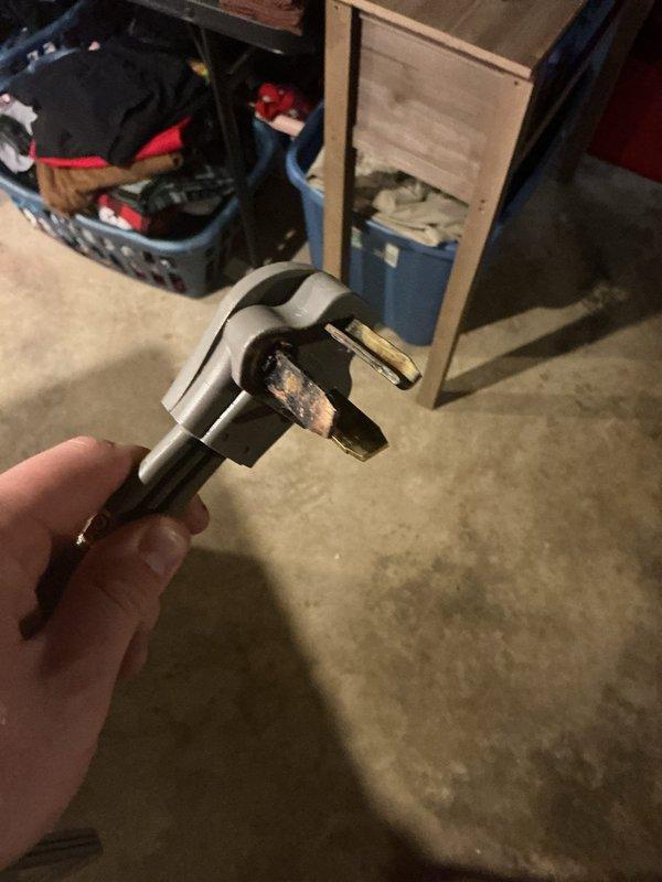 Replaced the heat-damaged pigtail on the dryer receptacle, which showed charring and corrosion on the prongs from a loose, overheated connection. Installed a new 30-amp, 3-prong dryer cord and terminated it securely to the receptacle to restore safe, reliable power to the dryer circuit.