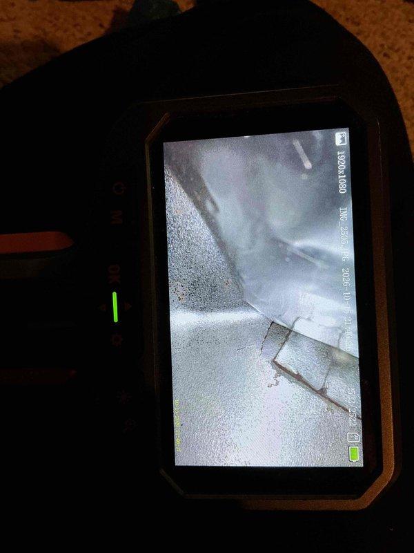 Performed a furnace inspection in response to a reported cracked heat exchanger, using a borescope to visually examine the heat exchanger and surrounding internal surfaces. Imaging showed a visible seam and gap with surface corrosion and discoloration on the sheet metal, and repairs are recommended before maintenance can be performed.