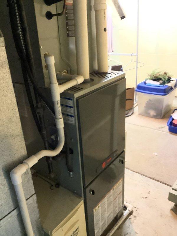 Performed an estimate for replacement of a 13-year-old Trane gas furnace after diagnosing a cracked heat exchanger, which poses a safety risk and warrants unit replacement. Inspected the existing installation, including PVC condensate/vent piping, flue connections, and the Aprilaire humidifier mounted on the supply plenum, and documented conditions to support the replacement quote.