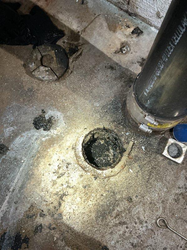 Removed the cleanout cap and pumped down the main drain line to clear standing wastewater, then cleared the blockage with a drain cleaning machine, retrieving a heavy mass of sludge, hair-like debris, and root-type fibrous material from the line. The main drain is now flowing freely, restoring use of the facilities.