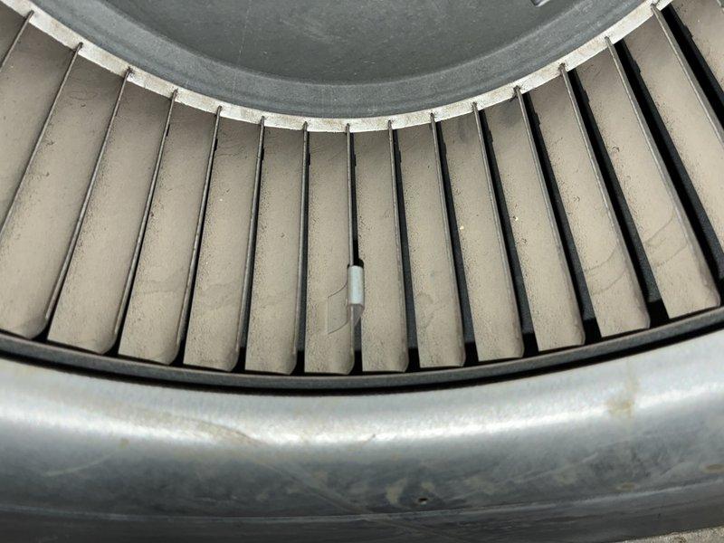 Performed scheduled heating maintenance on a 10-year-old furnace, inspecting the control board, wiring harness, and connections and noting surface corrosion on the cabinet wall. Inspected the blower assembly and found heavy dust accumulation on the blower wheel blades and a foreign object lodged between the blades, indicating the wheel requires cleaning to restore proper airflow and system efficiency.