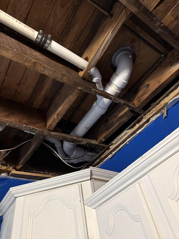 Replaced the cast iron main drain stack with PVC from the basement up to the access behind the tub, installed a new toilet flange, and tied back into the existing tub and lavatory drains. Installed a new 40-gallon short water heater with code-required upgrades, including a new expansion tank and updated flue and supply connections. Opened the basement landing wall to gain access for the stack replacement.