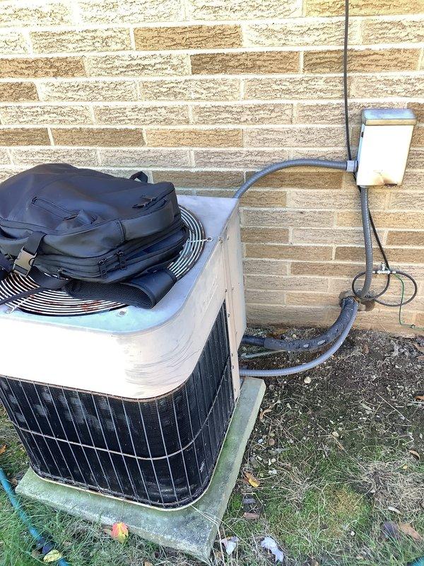 Performed an on-site estimate for replacement of the existing furnace and air conditioning system. Inspected the outdoor condenser unit and its electrical disconnect and conduit, noting surface wear, rust spots on the fan guard, and heavy debris buildup on the coil panel. Evaluated the indoor furnace area, including the galvanized ductwork transition and flue/vent connection at the floor penetration, to determine equipment sizing and installation requirements for the replacement.