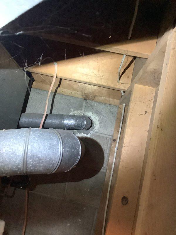 Performed an on-site estimate for replacement of the existing furnace and air conditioning system. Inspected the outdoor condenser unit and its electrical disconnect and conduit, noting surface wear, rust spots on the fan guard, and heavy debris buildup on the coil panel. Evaluated the indoor furnace area, including the galvanized ductwork transition and flue/vent connection at the floor penetration, to determine equipment sizing and installation requirements for the replacement.