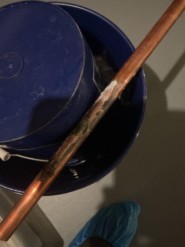 Located and repaired a leak in the copper supply line running from the water heater toward the master bedroom, where corrosion, verdigris, and mineral buildup had compromised the pipe. Removed the failed section and replaced it with new copper using soldered fittings, then confirmed the repair was secure and leak-free under pressure. Protected the work area with shoe covers and containment buckets throughout the repair.