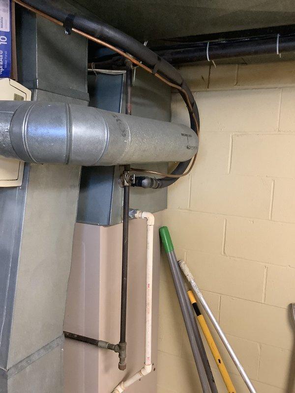 Performed an on-site replacement estimate for a 30+ year old gas-fired furnace, inspecting the burner assembly, gas valve, wiring, and flue piping, and noting general wear with discoloration on the flue pipe consistent with the unit's age. Reviewed the existing sheet metal plenum and ductwork, refrigerant line set, gas piping, and condensate/PVC routing to evaluate compatibility with a new system, and documented the installation with photos for the second-opinion evaluation.