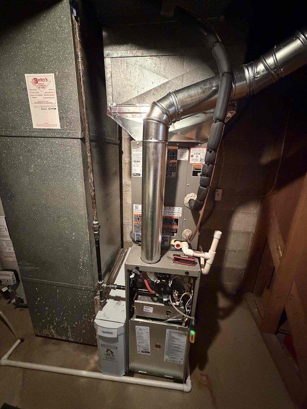 Installed a new 80% AFUE gas furnace with matching air conditioning system, including flue venting, PVC condensate drainage, and connections to the existing ductwork plenum. Wired the outdoor condenser through the electrical disconnect with new 25-amp cartridge fuses and verified the refrigerant line set and conduit connections. Completed system startup and checked for proper operation.