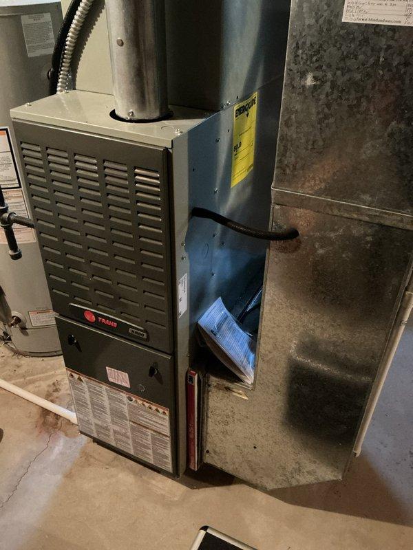 Performed a recurring seasonal heating maintenance visit on a Trane XR80 gas furnace, including inspection of the cabinet, flue connection, and control board wiring harness. Observed dust and debris buildup on interior surfaces and the blower/filter section, and verified the integrity of the electrical connections and safety labeling. Unit was left in operational condition.