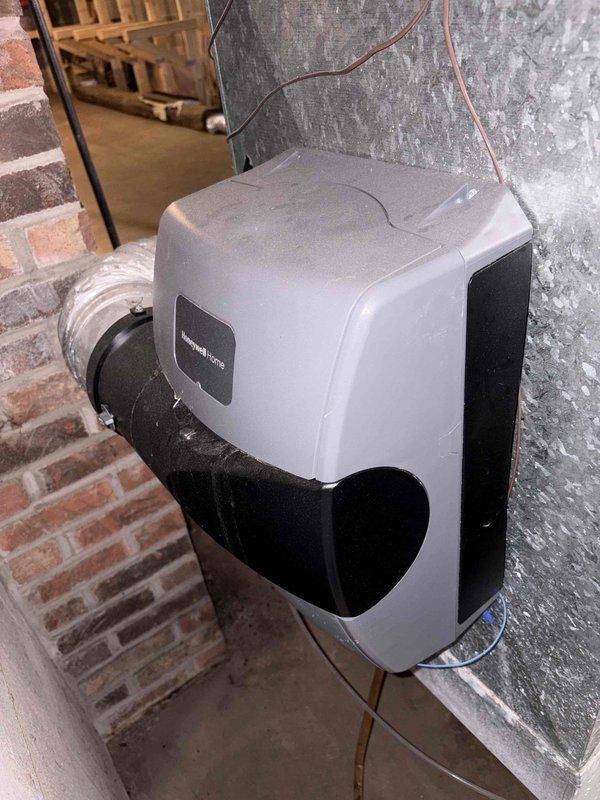 Performed an on-site furnace replacement estimate, evaluating the existing equipment area in the unfinished basement, including the Honeywell Home whole-house humidifier mounted on the supply plenum with flexible duct and control wiring, and noting no visible rust, frost, or cracking. Documented the adjacent main electrical panel and surrounding wiring, copper piping with shutoff valve, and available clearances for the new installation. Photos were captured to support equipment sizing and replacement scope.
