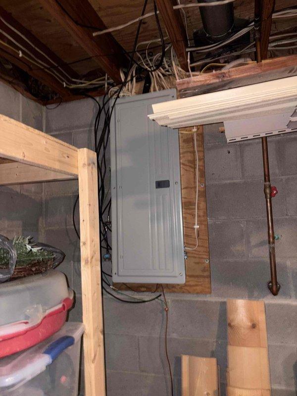 Performed an on-site furnace replacement estimate, evaluating the existing equipment area in the unfinished basement, including the Honeywell Home whole-house humidifier mounted on the supply plenum with flexible duct and control wiring, and noting no visible rust, frost, or cracking. Documented the adjacent main electrical panel and surrounding wiring, copper piping with shutoff valve, and available clearances for the new installation. Photos were captured to support equipment sizing and replacement scope.